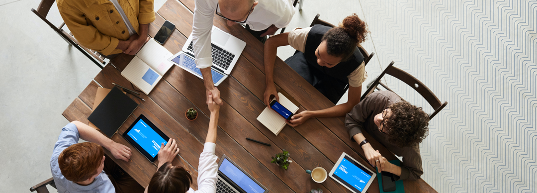 birds eye view of a business meeting with two people shaking hands across the table