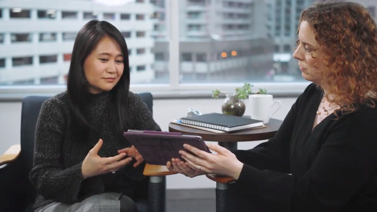 DIDM in SC20_header image_session An east Asian woman with long black hair seeking care looks over questionnaire results on a tablet held by her therapist, a white woman with long, curly red hair